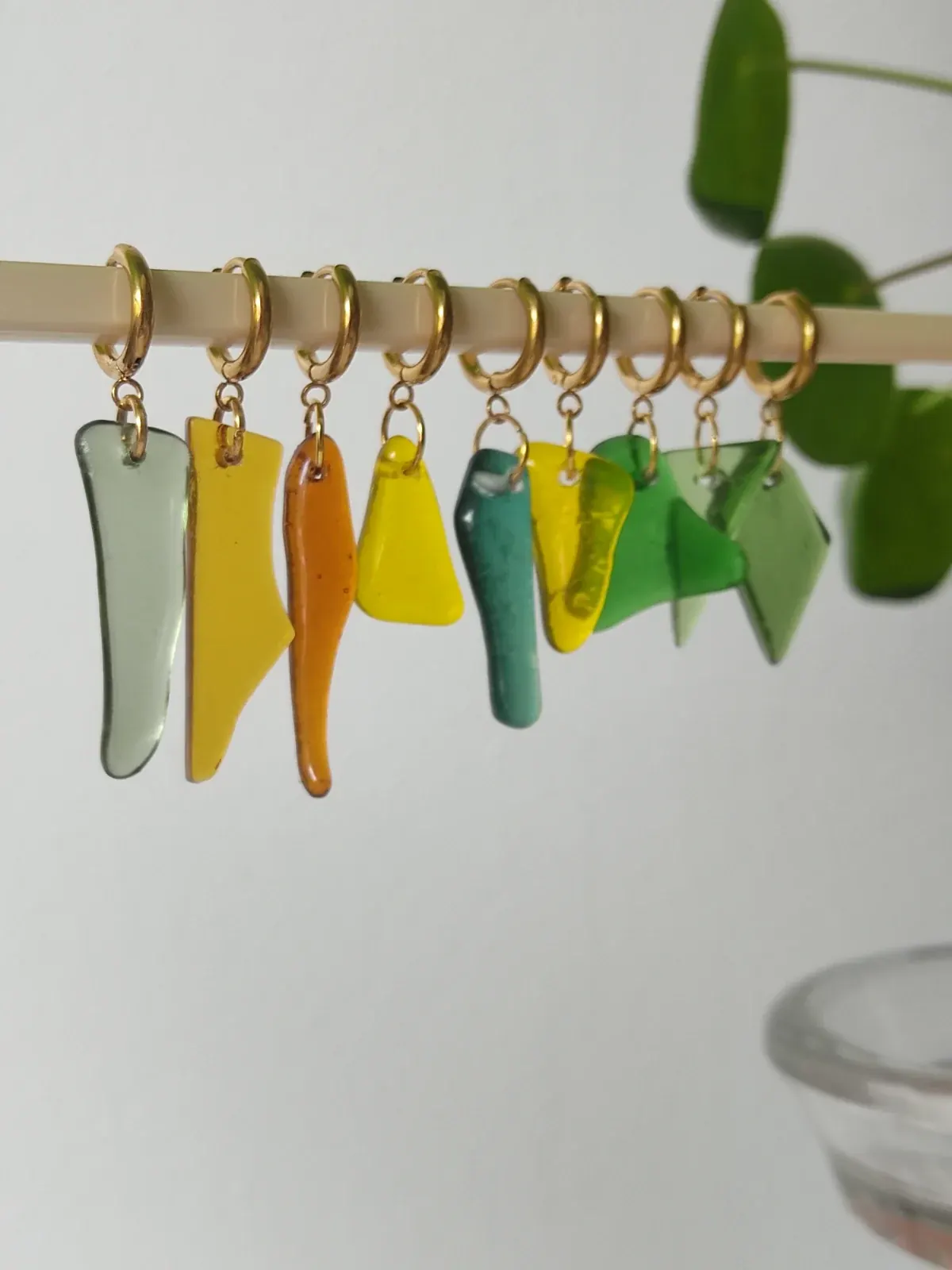 Assortiment de pièces en verre coloré et percé aux formes variées : bleu, rouge, vert, ambre et blanc.